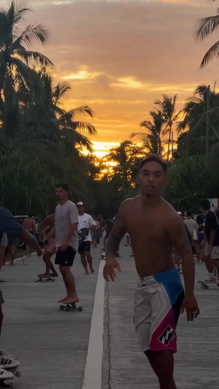 Danse et skate au coucher du soleil sur une route bordée de palmiers à Siargao