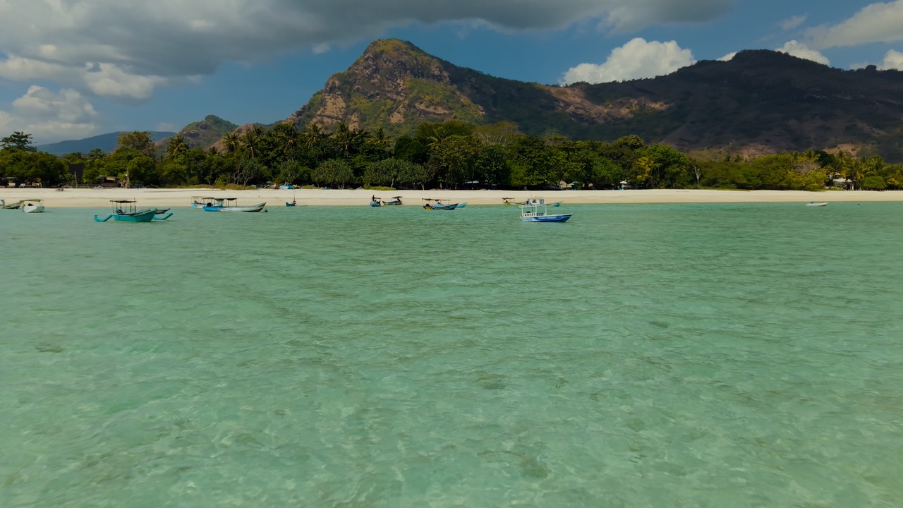 Bateau traditionnel sur un lagon turquoise filmé par drone