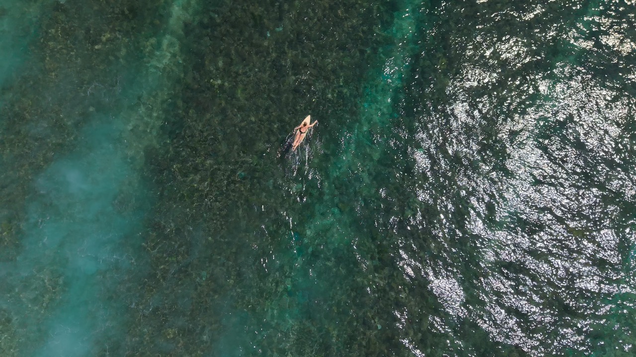 Bateau sur une eau turquoise vu à la verticale par drone